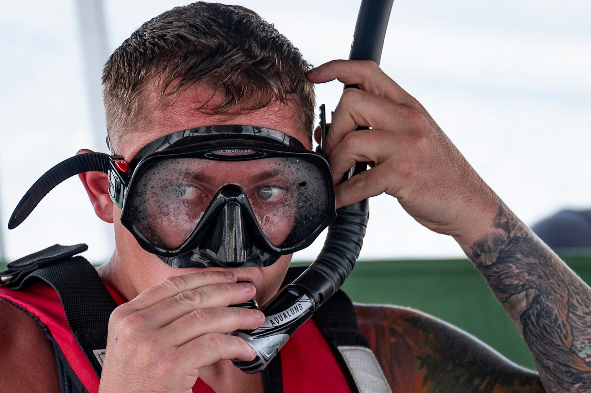 U.S. Army 1st Sgt. Peter Knope, United States Army Air Ambulance Detachment (USAAAD), 1st Battalion, 228th Aviation Regiment Joint Task Force-Bravo critical care flight paramedic, dons snorkeling gear for a simulated overwater hoist rescue at Lake Yojoa, Honduras, April 22, 2025. The rescue drills included utilizing hand signals for rescue to communicate the type of rescue hoist device to deploy. (U.S. Air Force photo by Staff Sgt. Sadie Colbert)