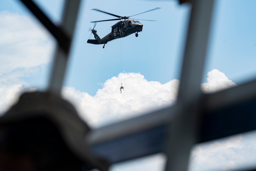 A HH-60L Black Hawk assigned to the United States Army Air Ambulance Detachment (USAAAD), 1st Battalion, 228th Aviation Regiment Joint Task Force-Bravo, deploys a rescue mannequin during a simulated overwater hoist rescue at Lake Yojoa, Honduras, April 22, 2025. The pilots use the mannequin to practice deploying a paramedic to a targeted area, ensuring quick care and efficiency during a rescue. (U.S. Air Force photo by Staff Sgt. Sadie Colbert)