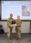 U.S. Air National Guard Technical Sgt. Jamie Gardner, 190th Air Refueling Wing,  poses with a plaque at Rosecrans Air National Guard Base, Missouri, April 16, 2025.