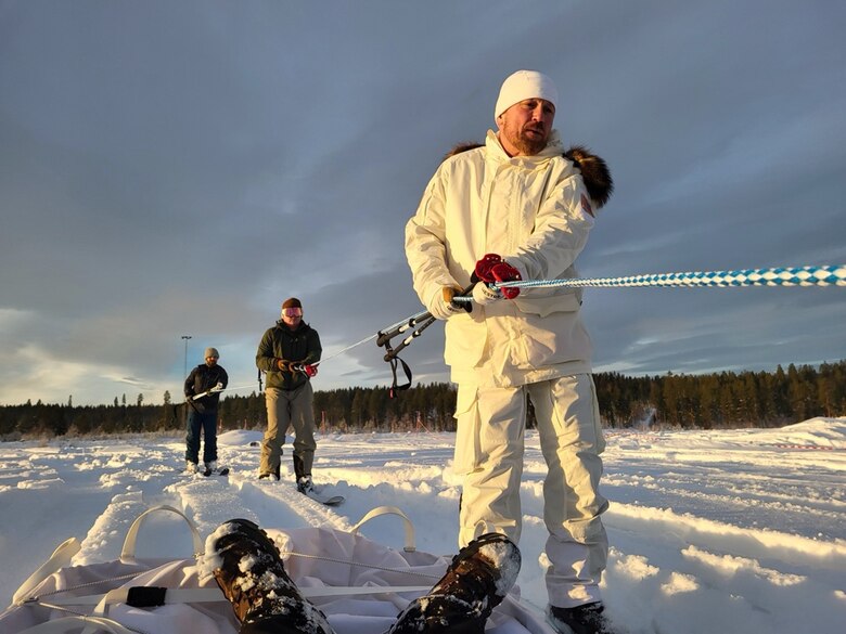 CRREL team members skijoring alongside an “injured” Warfighter during a CASEVAC exercise held as part of a USSOCOM Technical Experimentation this past winter at Camp Rødsmoen in Rena, Norway. Photo by Mike Parker, CRREL.