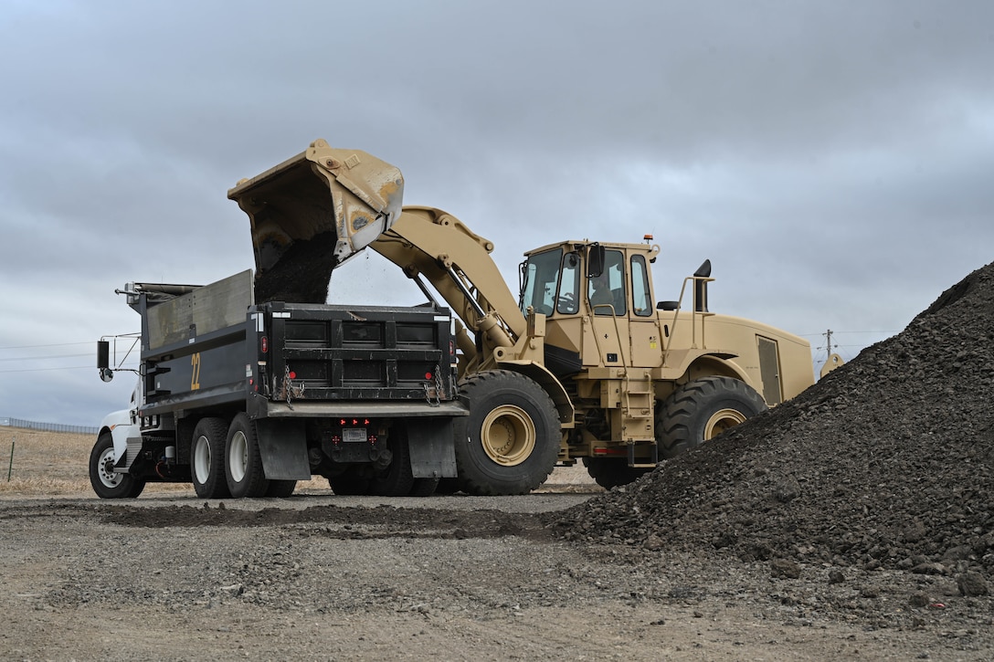 A wheel loader transfers recycled asphalt in a dump truck.