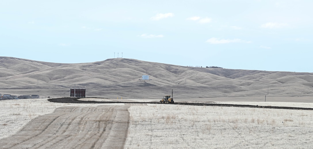A grader levels crushed asphalt.