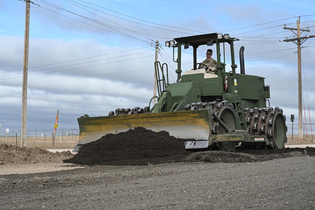A sheepsfoot roller compacts asphalt.