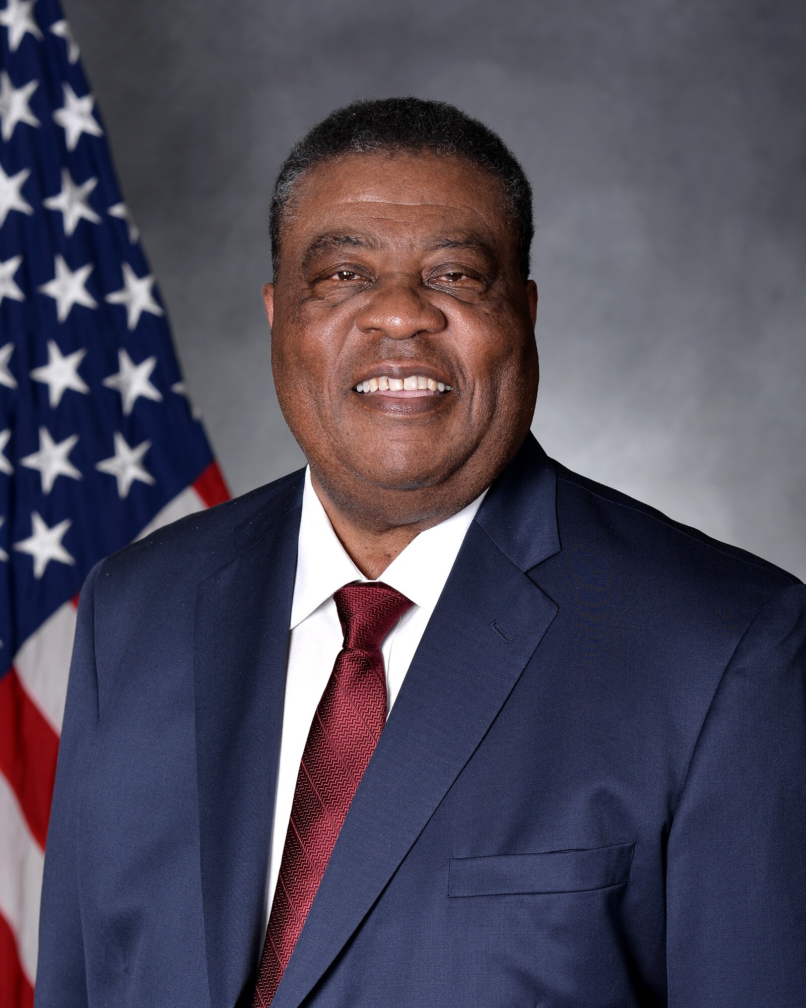 Man sits in front of United States flag for an official studio photo