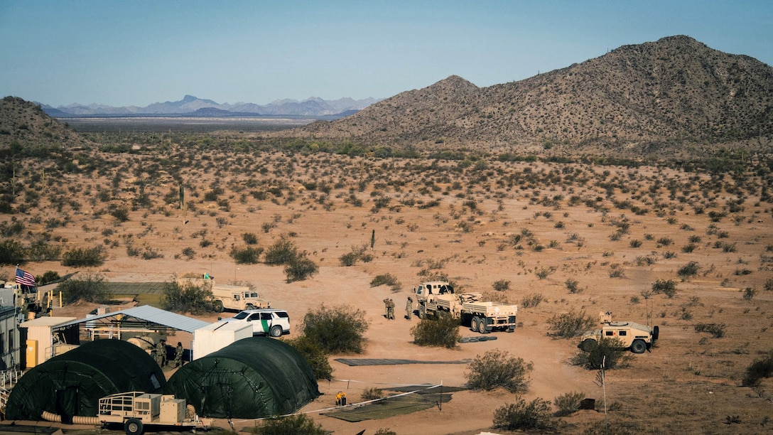 Soldier set up headquarters in a desert under a blue sky.