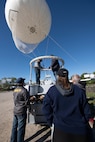 Five crew teammates overlooking a floating white balloon.
