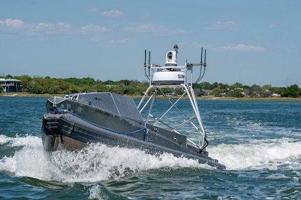 A photo of a Unmanned Autonomous System Boat moving in the water.