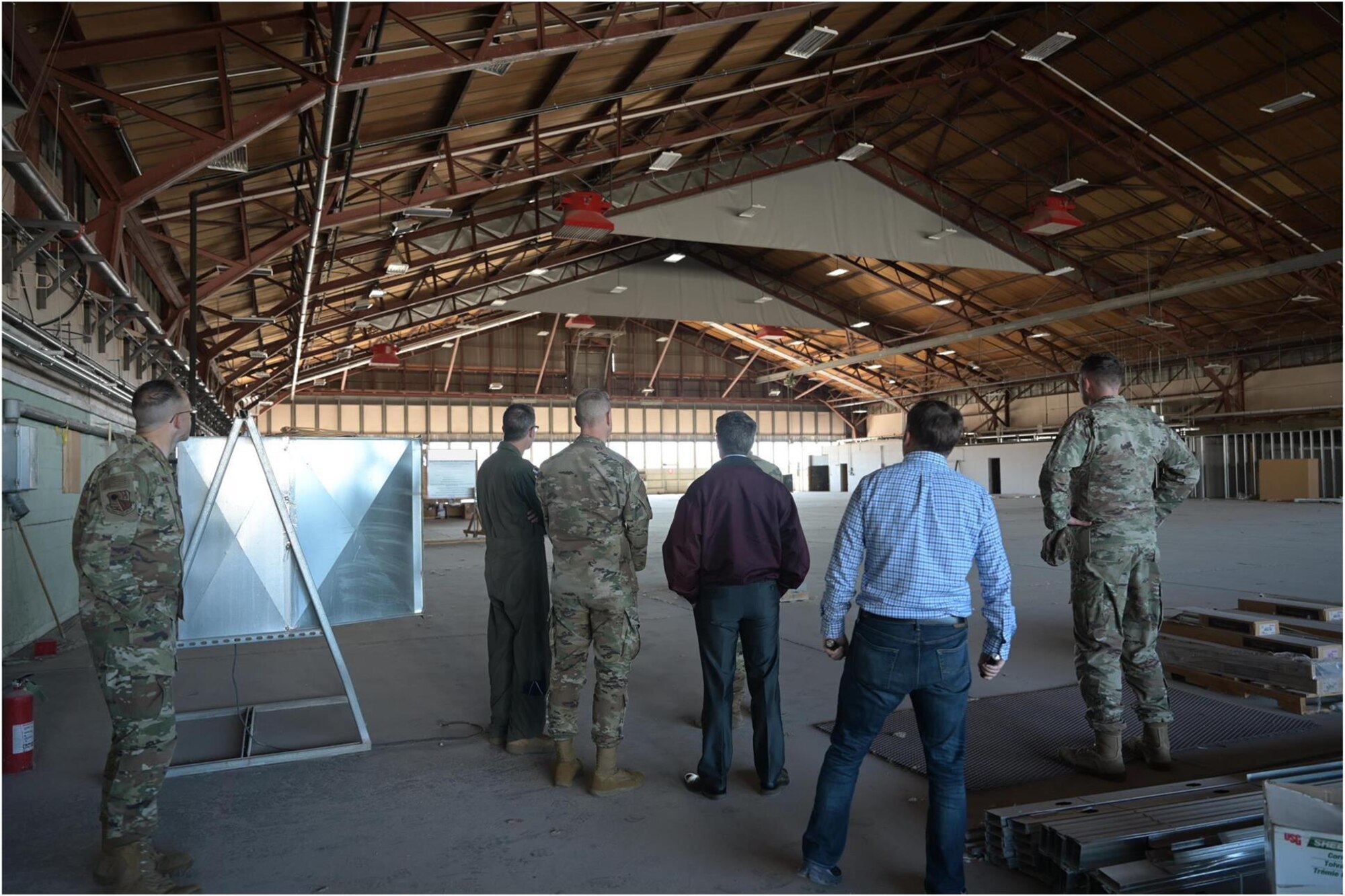 U.S. Air Force Maj. Gen. Scott Cain, Air Force Test Center commander, left, and U.S. Air Force Chief Master Sgt. Jeffrey Martin, AFTC command chief, checks an empty hangar with members of the 704th Test Group at Holloman Air Force Base, New Mexico, March 21, 2025. The 704th TG presented the AFTC command team with ideas on how to repurpose existing facilities to expand and improve workspace efficiency. This photo has been edited to redact OPSEC concerns. (U.S. Air Force photo by Airman 1st Class Bob Teichmann)