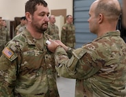 Col. Steven Engels, 75th Troop Command, pins Spc. Brandon Pollard with an Army Commendation Medal following his heroic actions following an accident in Shelby County, March 15, 2025.