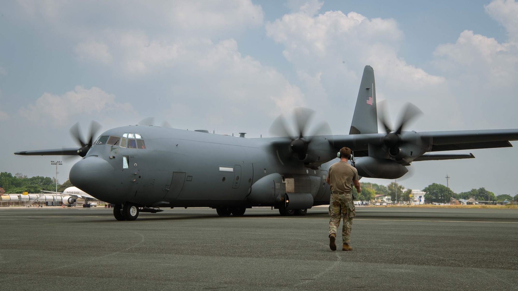 U.S. Air Force Senior Airman Aiden West, a crew chief with 317th Aircraft Maintenance Squadron, marshals a U.S. Air Force C-130J Super Hercules assigned to 39th Airlift Squadron, for a U.S. Army Humvee assigned to 5th Battalion, 3rd Field Artillery Regiment, 1st Multi Domain Task Force, transport during Exercise Balikatan 25 at at Clark Air Base, Philippines, April 23, 2025. Balikatan is a longstanding annual exercise between the Armed Forces of the Philippines and U.S. military designed to strengthen our ironclad alliance, improve our capable combined force, and demonstrate our commitment to regional security and stability. (U.S. Marine Corps photo by Sgt. Mitchell Johnson)