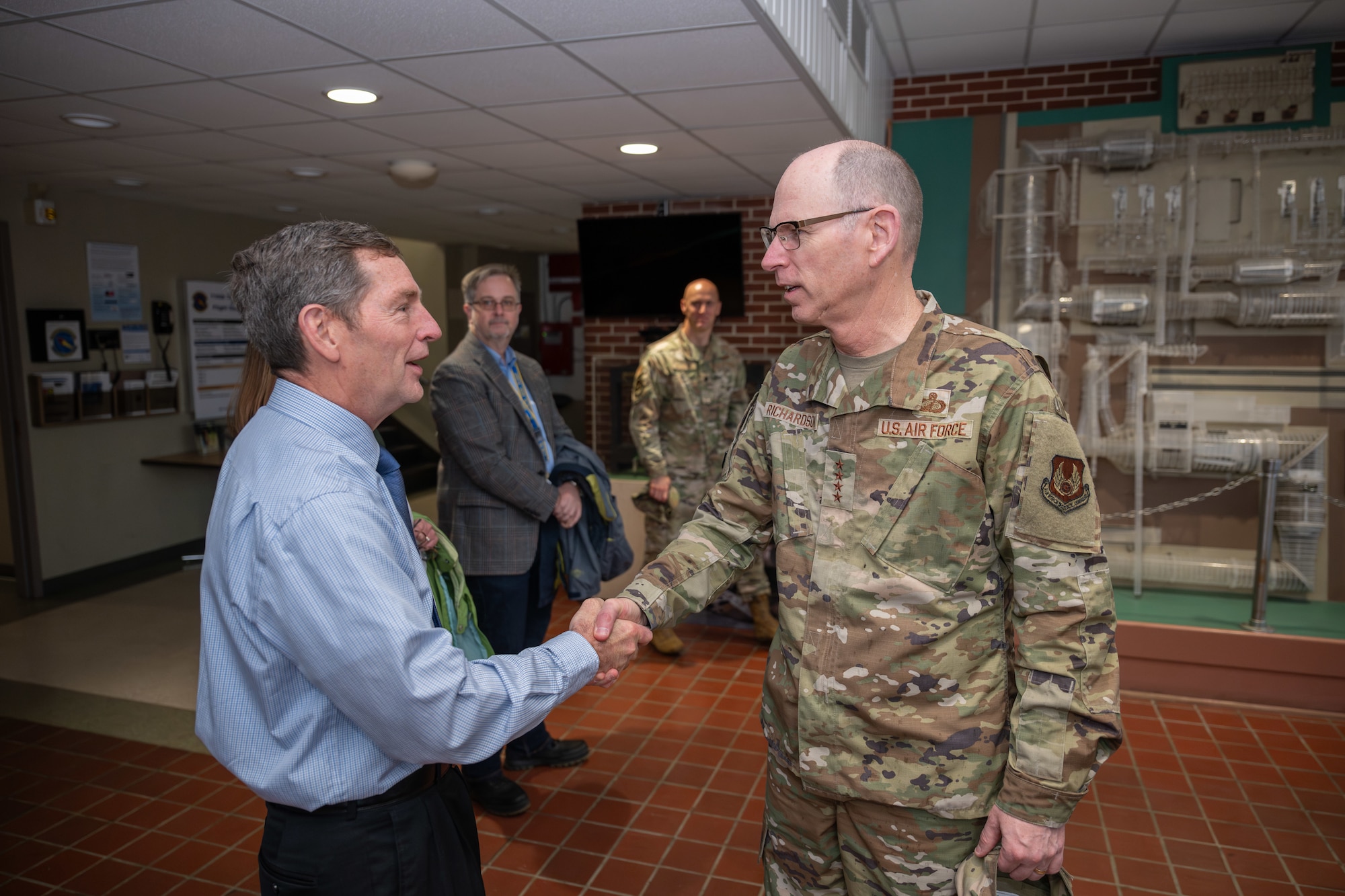 Gen. Duke Z. Richardson, commander of Air Force Materiel Command, right, is greeted by Arnold Engineering Development Complex Deputy Director Kevin Muckerheide April 24, 2025, in the lobby of the Propulsion Wind Tunnel Facility at Arnold Air Force Base, Tenn. Richardson visited Arnold AFB, headquarters of AEDC, to tour several test facilities, meet with personnel, and receive updates on various programs and projects. (U.S. Air Force photo by Keith Thornburgh)