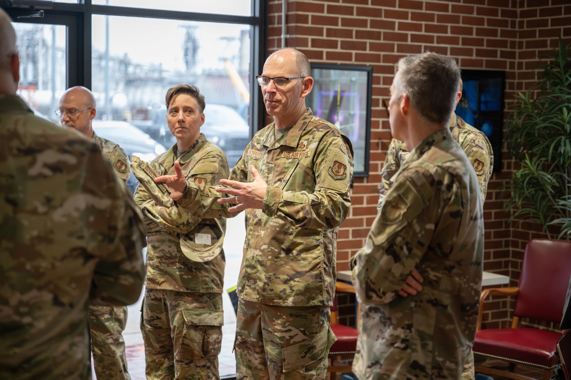 Gen. Duke Z. Richardson, commander of Air Force Materiel Command, center, speaks with Col. Grant Mizell, commander of Arnold Engineering Development Complex, right, and Chief Master Sgt. Jennifer Cirricione, AEDC senior enlisted leader, in the lobby of the Propulsion Wind Tunnel Facility April 24, 2025. Richardson visited Arnold AFB, headquarters of AEDC, to tour several test facilities, meet with personnel, and receive updates on various programs and projects. (U.S. Air Force photo by Keith Thornburgh)
