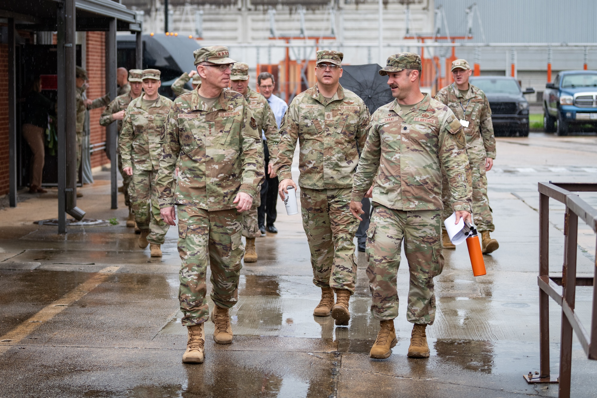 Gen. Duke Z. Richardson, commander of Air Force Materiel Command, left, speaks with Lt. Col. Joseph Sabat, 716th Test Squadron commander, right, outside of the Propulsion Wind Tunnel Facility lobby at Arnold Air Force Base, Tenn., April 24, 2025. Also pictured is Chief Master Sgt. Bill Fitch, AFMC Command Chief Master Sergeant, center. Richardson visited Arnold AFB, headquarters of Arnold Engineering Development Complex, headquarters of AEDC, to tour several test facilities, meet with personnel, and receive updates on various programs and projects. (U.S. Air Force photo by Keith Thornburgh) (This image was altered by obscuring badges for security purposes)