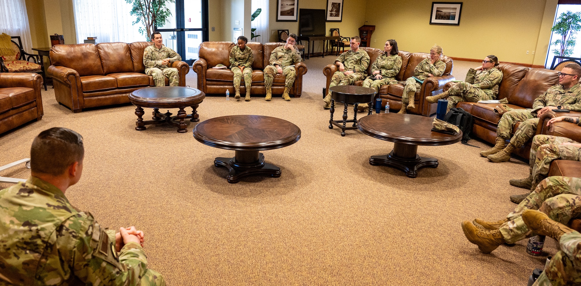 A group of airmen sit in a room during a discussion.