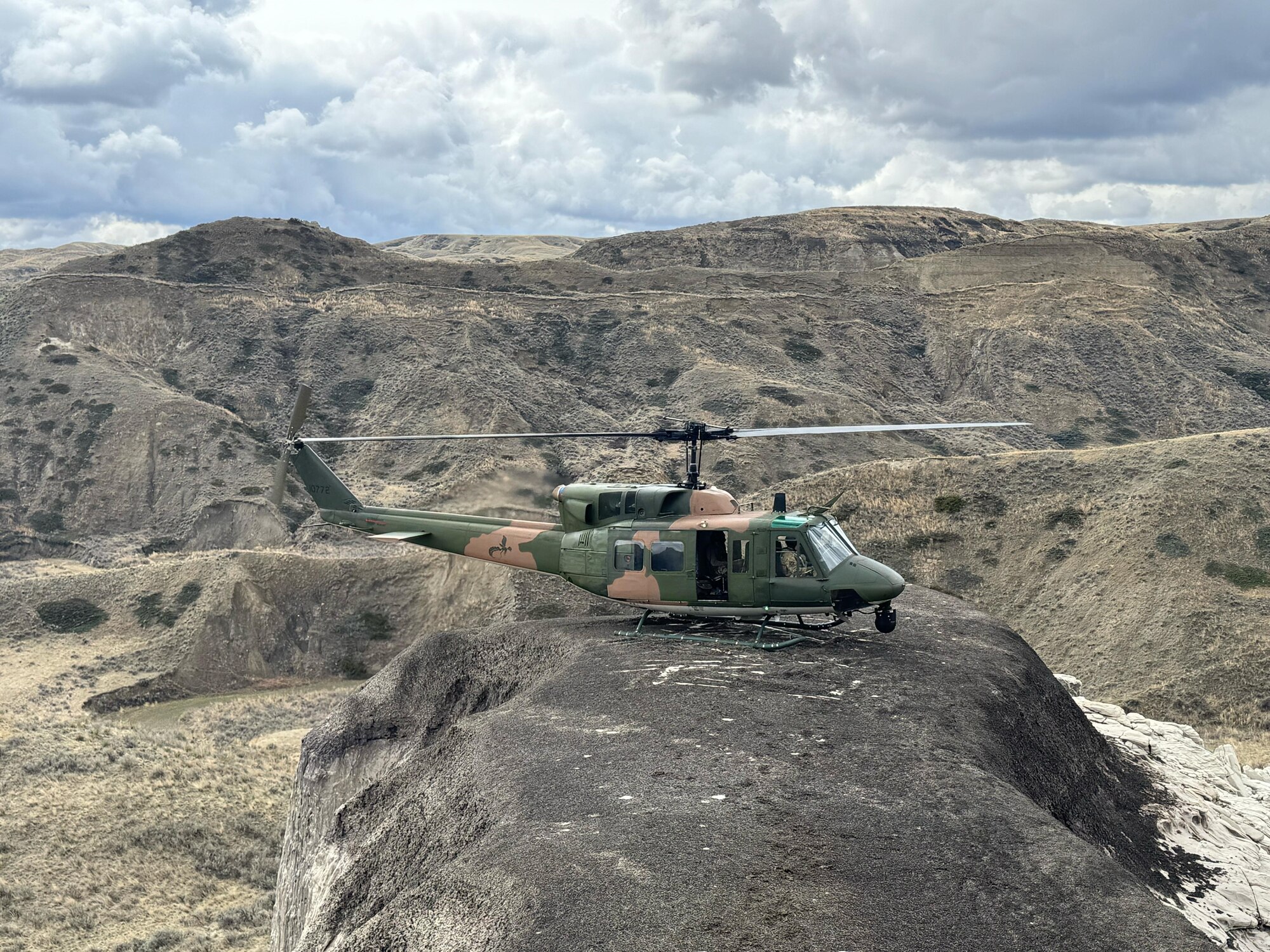 A helicopter landing on a ridgeline