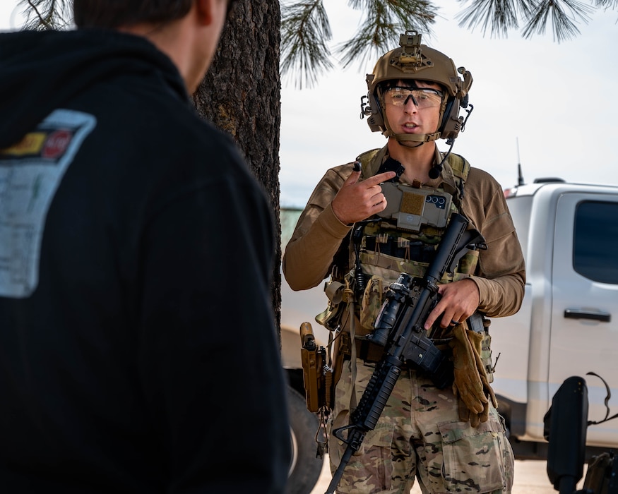 U.S. Air Force Senior Airman Matthew Helms, 56th Civil Engineer Squadron explosive ordnance disposal technician, discusses a retrieval plan for mock ordnances during a field exercise.