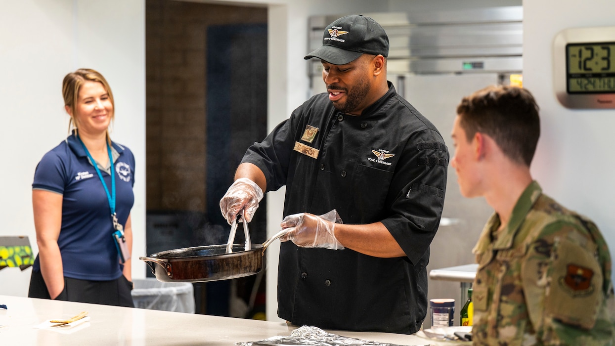 U.S. Air Force Staff Sgt. Larry Covington (center), 56th Force Support Squadron catering craftsman, sautés vegetables during a dorm cooking class