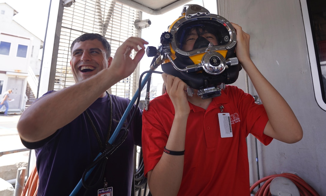 Student puts on dive helmet