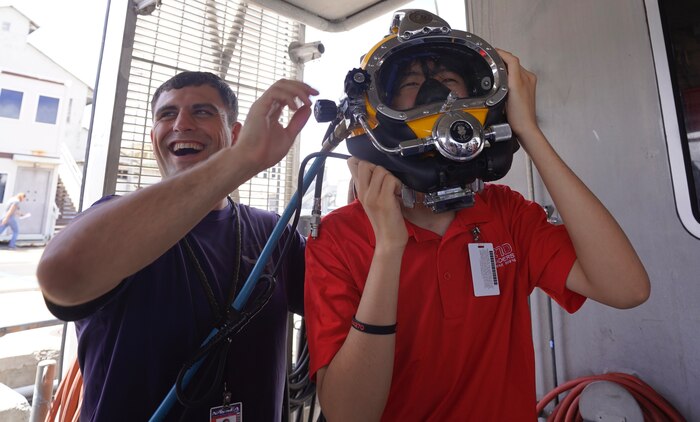 Student puts on dive helmet