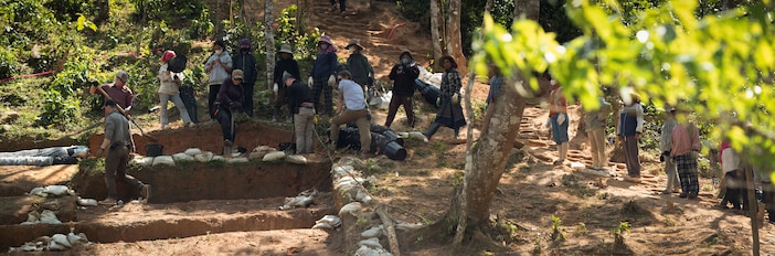 Defense POW/MIA Accounting Agency 25-2VN recovery team members and local Vietnamese workers excavate an archaeological unit and pass material to a wet screening station during a recovery operation in Vietnam, March 9, 2025.