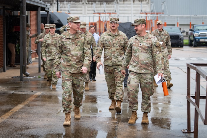 Gen. Duke Z. Richardson, commander of Air Force Materiel Command, left, speaks with Lt. Col. Joseph Sabat, 716th Test Squadron commander, right, outside of the Propulsion Wind Tunnel Facility lobby at Arnold Air Force Base, Tenn., April 24, 2025. Also pictured is Chief Master Sgt. Bill Fitch, AFMC Command Chief Master Sergeant, center. Richardson visited Arnold AFB, headquarters of Arnold Engineering Development Complex, headquarters of AEDC, to tour several test facilities, meet with personnel, and receive updates on various programs and projects. (U.S. Air Force photo by Keith Thornburgh) (This image was altered by obscuring badges for security purposes)