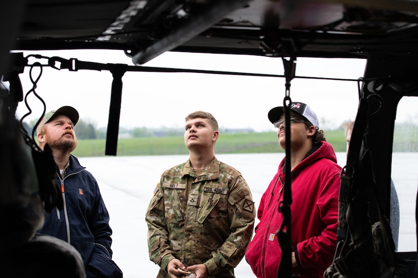Pfc. Trevor Holt shows family members components of the UH60 Black Hawk after the deployment ceremony on April 25, 2025 in Frankfort, Kentucky. Approximately 30 Soldiers from the 2-238th are deploying to Europe in support of intratheater aeromedical evacuations. (U.S. Army National Guard photo by Sgt. First Class Ryan Wilhoit)