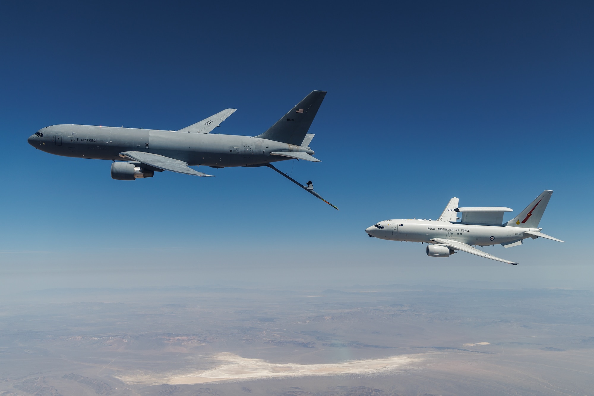 A KC-46A assigned to the 418th Flight Test Squadron at Edwards Air Force Base positions to refuel a Royal Australian Air Force E-7A Wedgetail in the airspace near Edwards. Aircrews from the USAF, RAAF, and Royal Air Force worked together to rapidly certify this enhanced combat capability for the RAAF E-7A fleet. The trilateral test also allowed the United Kingdom and United States Air Force to gain early test experience ahead of their anticipated fielding of E-7 aircraft variants. (Air Force photo by Richard Gonzales)