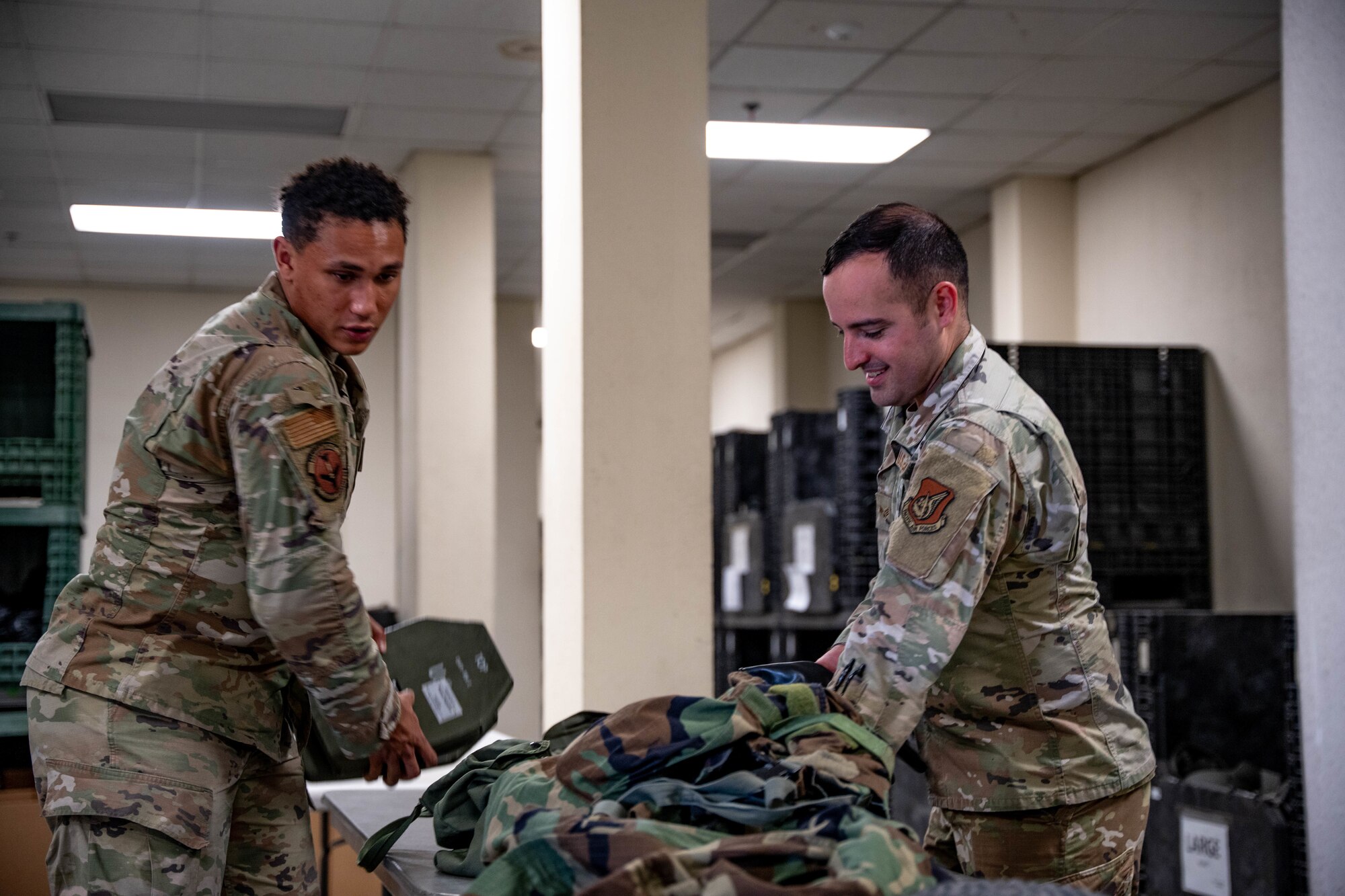 U.S. Air Force Senior Airmen Oliver Kollock, 51st Logistics Readiness Squadron individual protective equipment journeyman, left, issues IPE to installation members at Osan Air Base, April 16, 2025.