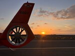 An MH-65 Dolphin helicopter assigned to Coast Guard Air Station Barbers Point in Kapolei, Hawaii, sits at Kona International Airport in Kaiminani, Hawaii, April 27, 2025. Helicopter and HC-130 Hercules airplane crews searched for a missing 42-year-old man after good Samaritans found his kayak unmanned and adrift 400 yards offshore Keauhou, Hawaii. (U.S. Coast Guard photo by Lt. Olivia Holt)