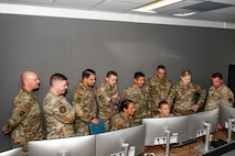 a group of people standing around a computer
