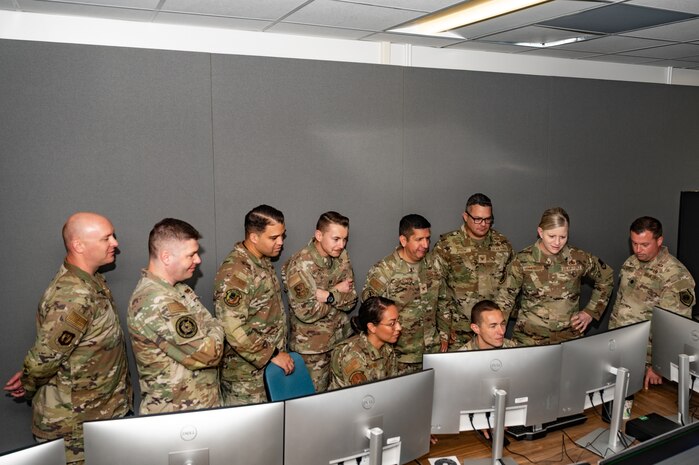 a group of people standing around a computer