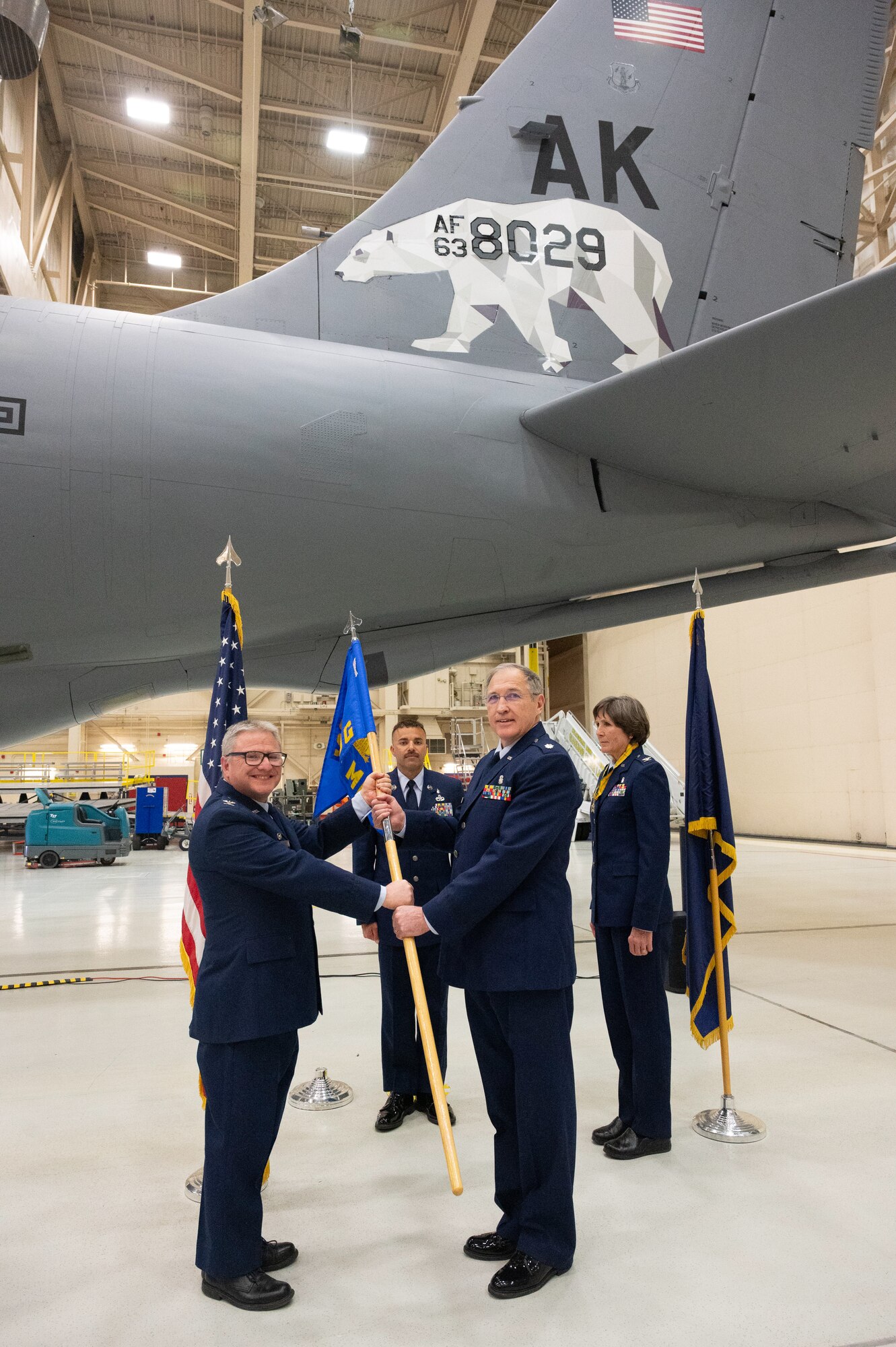Col. Michael S. Griesbaum,168th Wing commander, passes the 168th Medical Group guidon to Lt. Col. Russell S. Pierce, right, 168th Medical Group incoming commander, during the 168 MDG change of command ceremony.