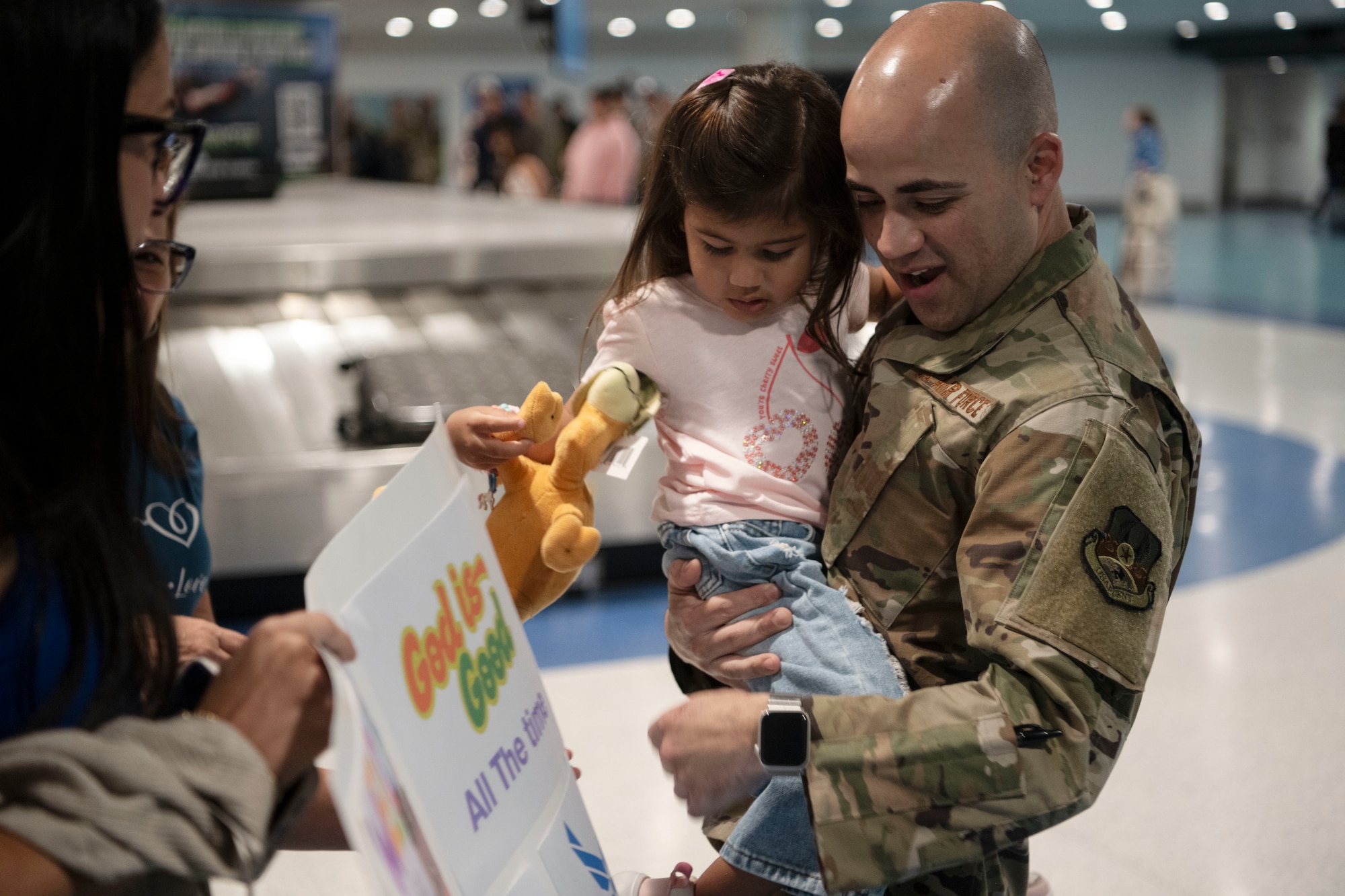 U.S. Air Force Master Sgt. Jonathan Ortiz, power production specialist, 141st Air Control Squadron, Puerto Rico Air National Guard, holds his daughter at the Luis Muñoz Marin International Airport, Carolina, Puerto Rico, April, 18, 2025. Over 50 Airmen with the 141st ACS arrived from a deployment overseas in support of global contingency operations. (U.S. Air National Guard photo by Master Sgt. Rafael Rosa)