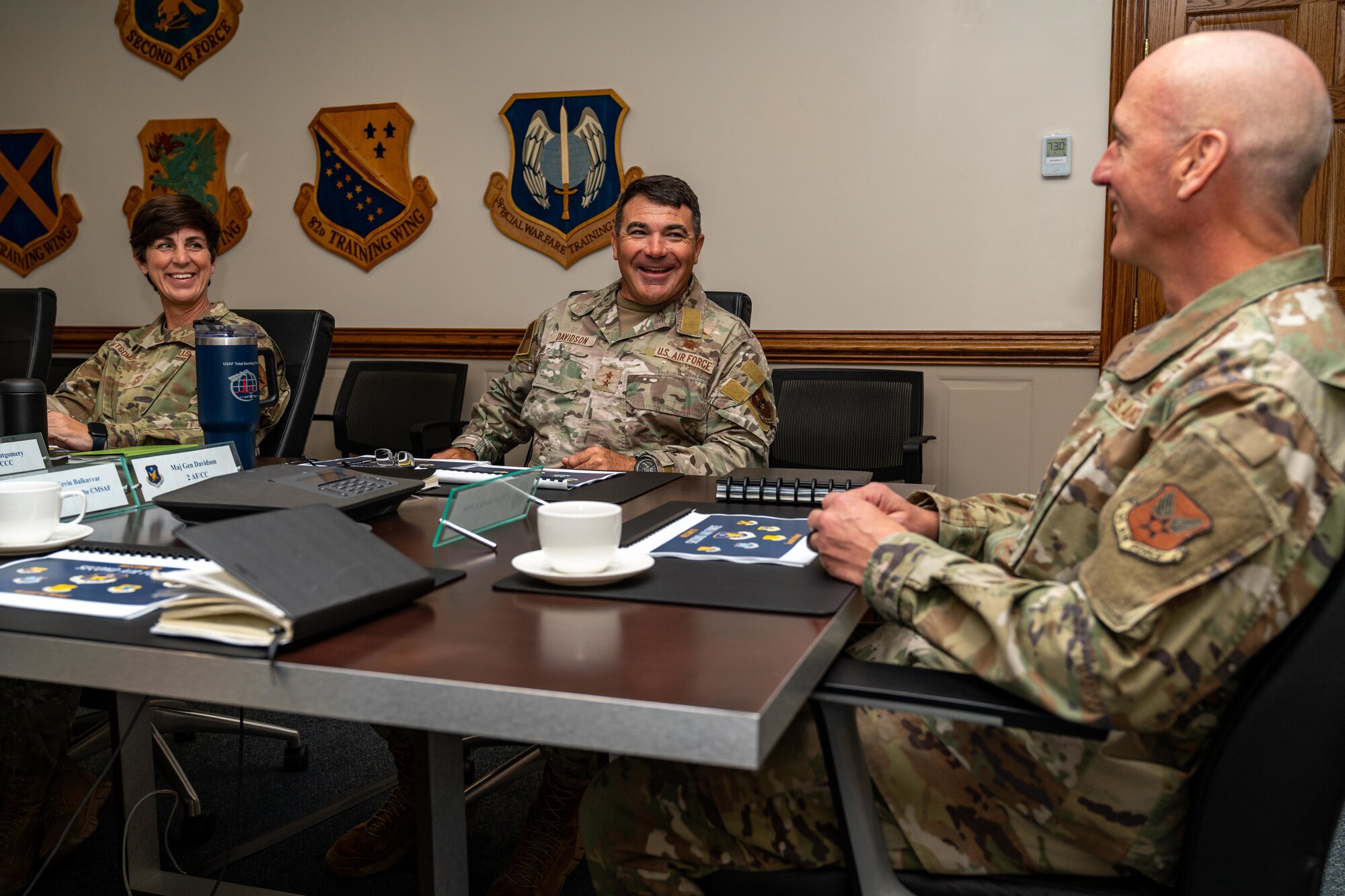 Airmen sitting around a table in a briefing room.