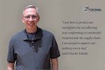 Smiling man wears glasses and a gray short-sleeved collared shirt