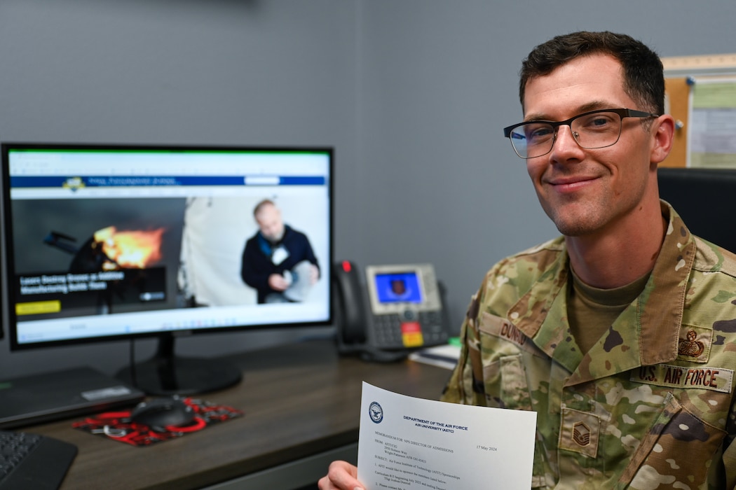 U.S. Air Force Master Sgt. Joshua D. Dunrud, 97th Contracting Squadron senior enlisted leader, holds his Naval Postgraduate School (NPS) acceptance email at his desk at Altus Air Force Base, Oklahoma, April 23, 2025. NPS offers advanced courses on defense contracting to both civilian and military personnel. (U.S. Air Force Photo by Airman 1st Class Nathan Langston)