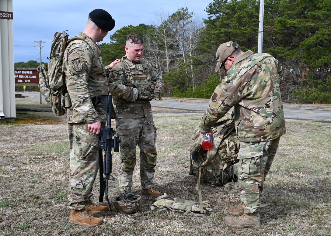 U.S. Air Force Airman 1st Class Elijah Harris, 104th Fighter Wing (FW) public affairs specialist, and Tech. Sgt Shane Coakley, 104th FW Security Forces, watch Senior Master Sgt. Adam Casineau, 104th Fighter Wing, organize gear at the Massachusetts National Guard 2025 Best Warrior Competition, Camp Edwards, Massachusetts, April 11, 2025. Harris represented the 104th FW while competing against members of the Air and Army National Guard, Kenya Defense Forces and Irish Defense Forces. (U.S. Air National Guard Photo by Melanie J. Casineau)