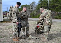 U.S. Air Force Airman 1st Class Elijah Harris, 104th Fighter Wing (FW) public affairs specialist, and Tech. Sgt Shane Coakley, 104th FW Security Forces, watch Senior Master Sgt. Adam Casineau, 104th Fighter Wing, organize gear at the Massachusetts National Guard 2025 Best Warrior Competition, Camp Edwards, Massachusetts, April 11, 2025. Harris represented the 104th FW while competing against members of the Air and Army National Guard, Kenya Defense Forces and Irish Defense Forces. (U.S. Air National Guard Photo by Melanie J. Casineau)
