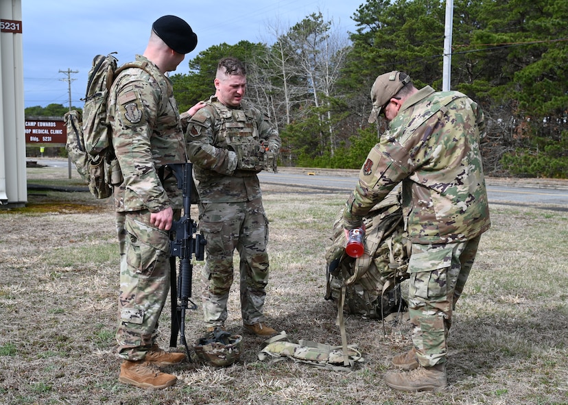 U.S. Air Force Airman 1st Class Elijah Harris, 104th Fighter Wing (FW) public affairs specialist, and Tech. Sgt Shane Coakley, 104th FW Security Forces, watch Senior Master Sgt. Adam Casineau, 104th Fighter Wing, organize gear at the Massachusetts National Guard 2025 Best Warrior Competition, Camp Edwards, Massachusetts, April 11, 2025. Harris represented the 104th FW while competing against members of the Air and Army National Guard, Kenya Defense Forces and Irish Defense Forces. (U.S. Air National Guard Photo by Melanie J. Casineau)