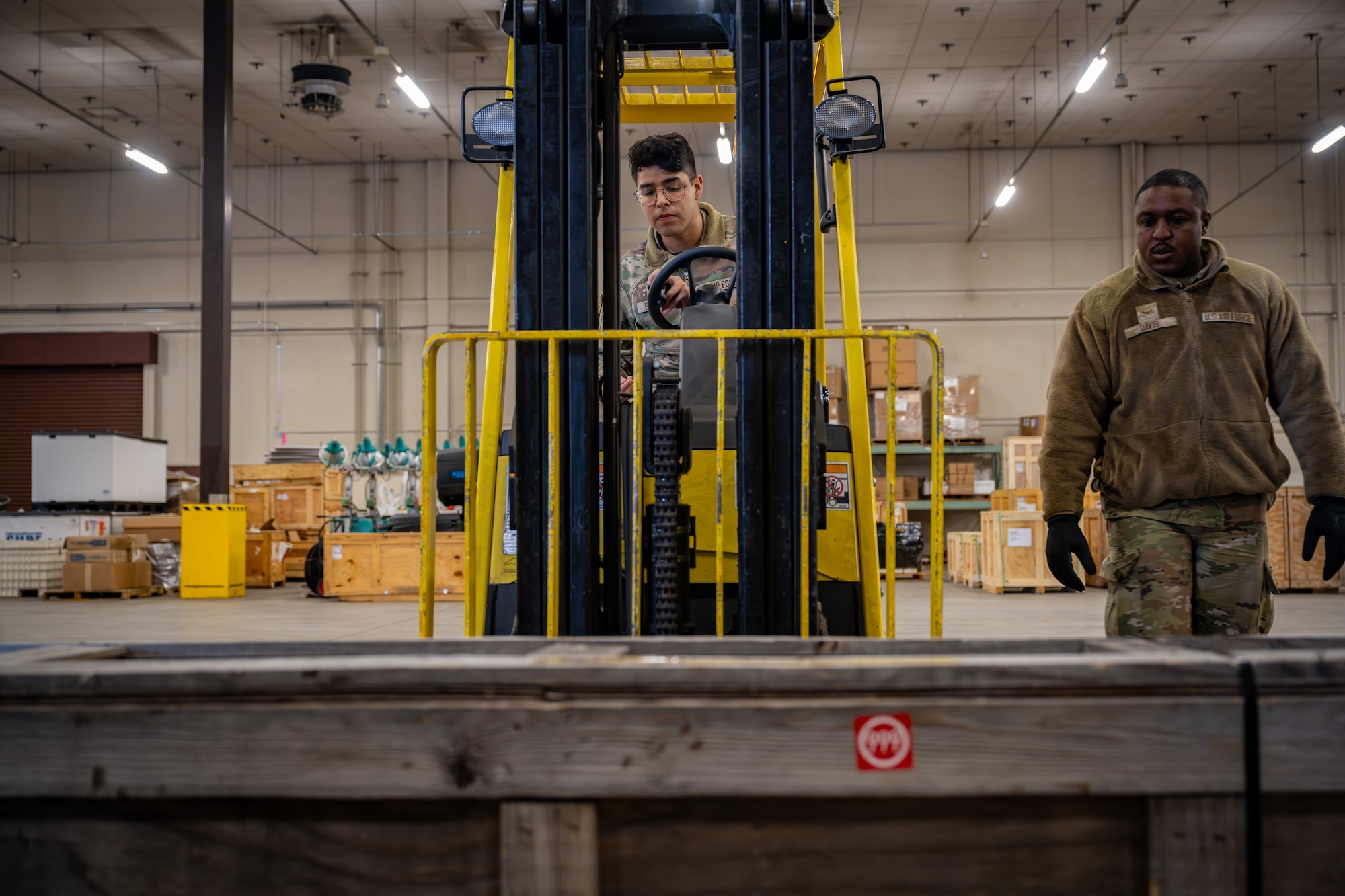 U.S. Air Force Senior Airman Steven Barboza, left, and U.S. Air Force Airman 1st Class Andrew Davis, 35th Logistic Readiness Squadron (LRS) ground transport operators, work together to operate a forklift for the Rhino Express program.