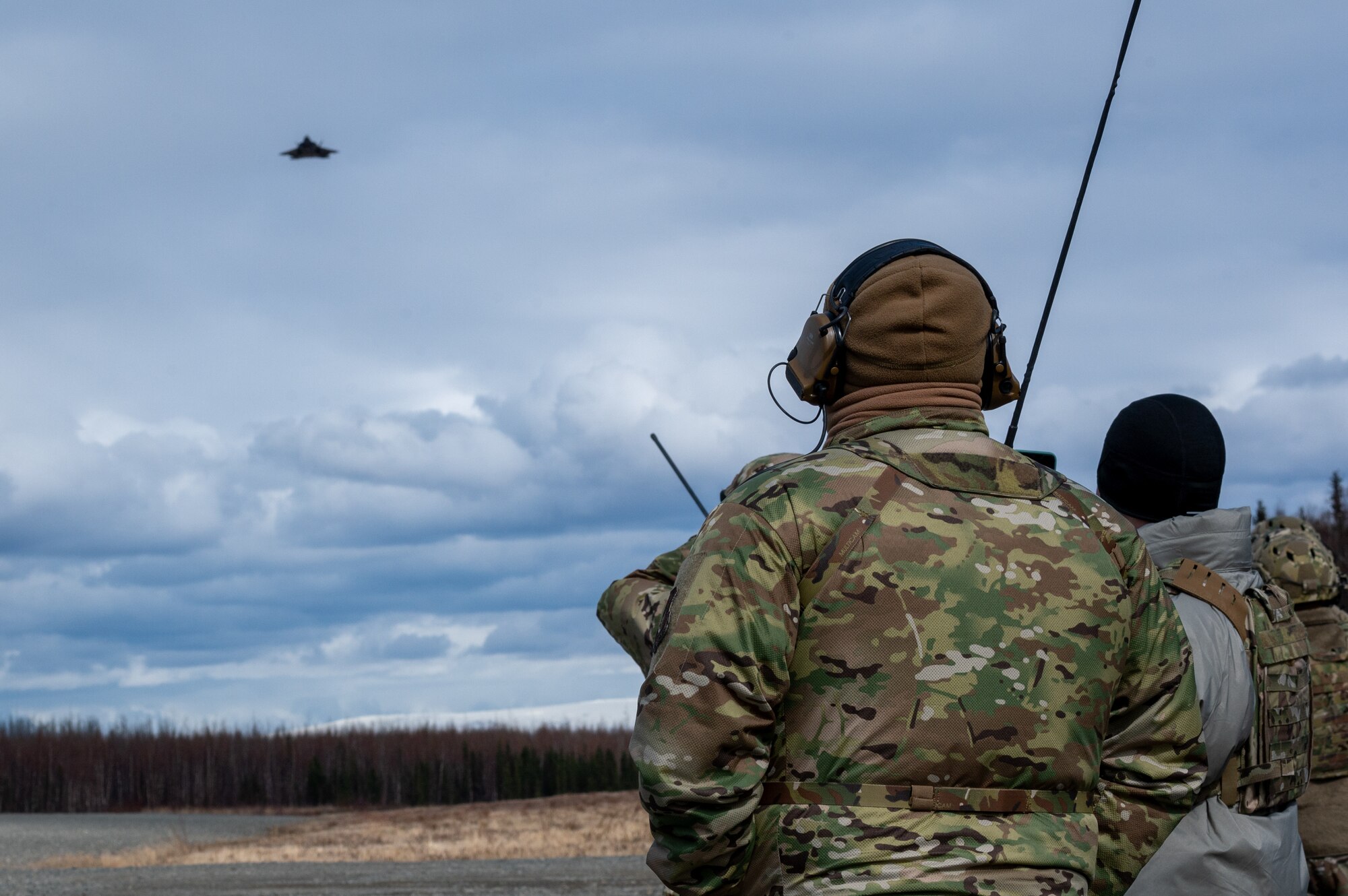 U.S. Air Force Airmen assigned to 3rd Operations Support Squadron conduct Landing Zone Safety Officer training at Malamute Drop Zone with F-22 Raptors assigned to 90th Fighter Squadron on Joint Base Elmendorf-Richardson, Alaska, April 21, 2025.