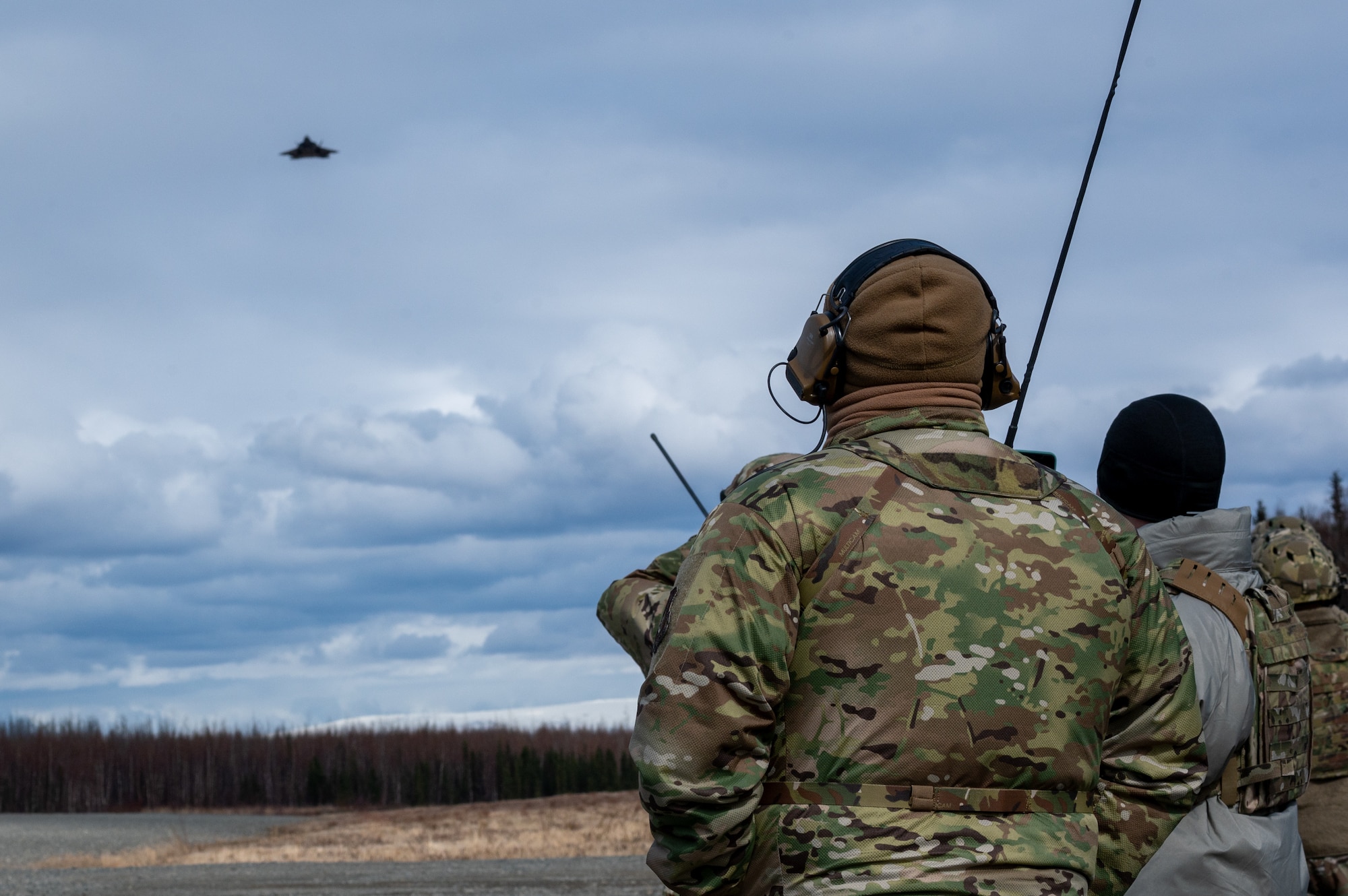 U.S. Air Force Airmen assigned to 3rd Operations Support Squadron conduct Landing Zone Safety Officer training at Malamute Drop Zone with F-22 Raptors assigned to 90th Fighter Squadron on Joint Base Elmendorf-Richardson, Alaska, April 21, 2025.