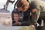 U.S. Air Force Captain Colin Klopp, 455th Flying Training Squadron instructor pilot, helps the 479th Flying Training Group’s “Aviator of the Day” Ava Seymour adjust her helmet aboard a T-6A Texan II, April 18, 2025, at Naval Air Station Pensacola, Florida. The “Aviator for a Day” program opens its hangars to children battling serious medical challenges, offering them a chance to suit up, take flight in simulators, and receive honorary aviator wings. (U.S. Air Force photo by Captain Laura Kane)