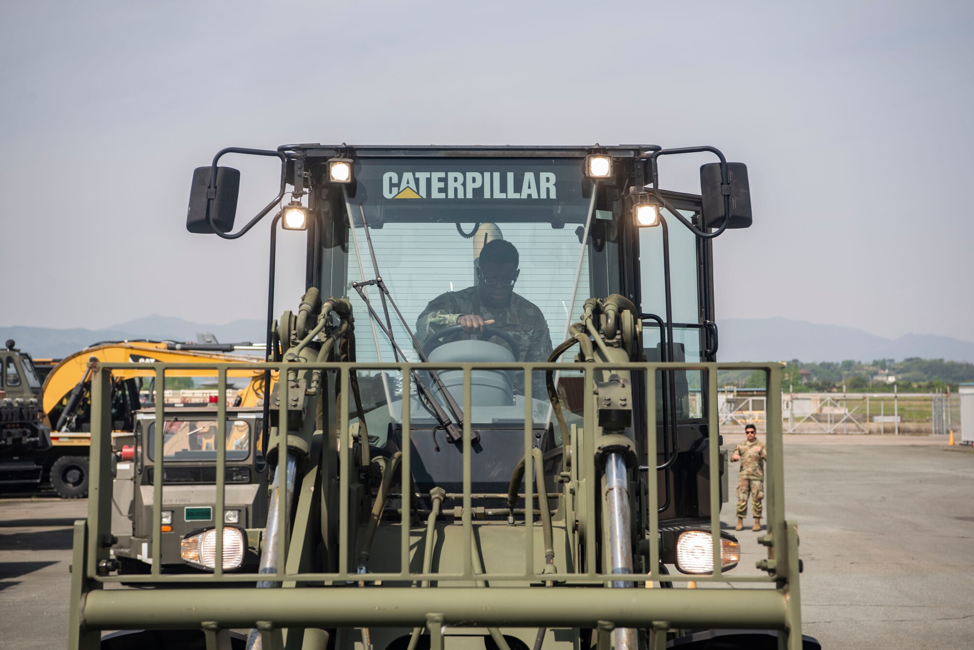 An airman sits in a forklift