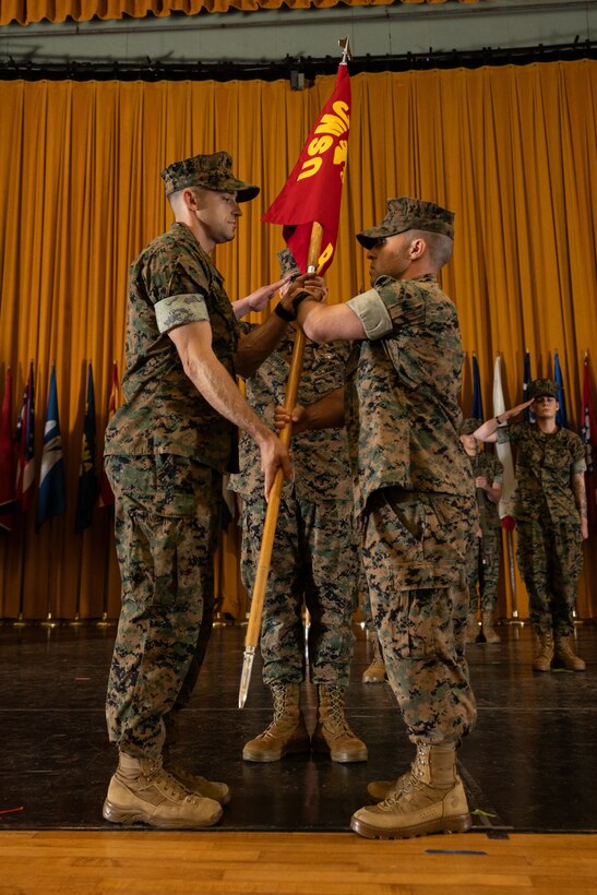 U.S. Marine Corps Capt. Pruitt Griffin, left, the incoming company commander for Bravo Company, Headquarters and Support Battalion, Marine Corps Installations Pacific receives the company colors from Capt. Matthew Mogish, the outgoing company commander of B Co, H&S Bn, MCIPAC, during a change of command ceremony on Camp Foster, Okinawa, Japan, April 25, 2025. Mogish served two years as the company commander and was relieved by Griffin, who previously served as the plans and program officer of G-6, MCIPAC. Mogish is a native of Texas and Griffin is a native of Mississippi. (U.S. Marine Corps photo by Lance Cpl. Brody Robertson)