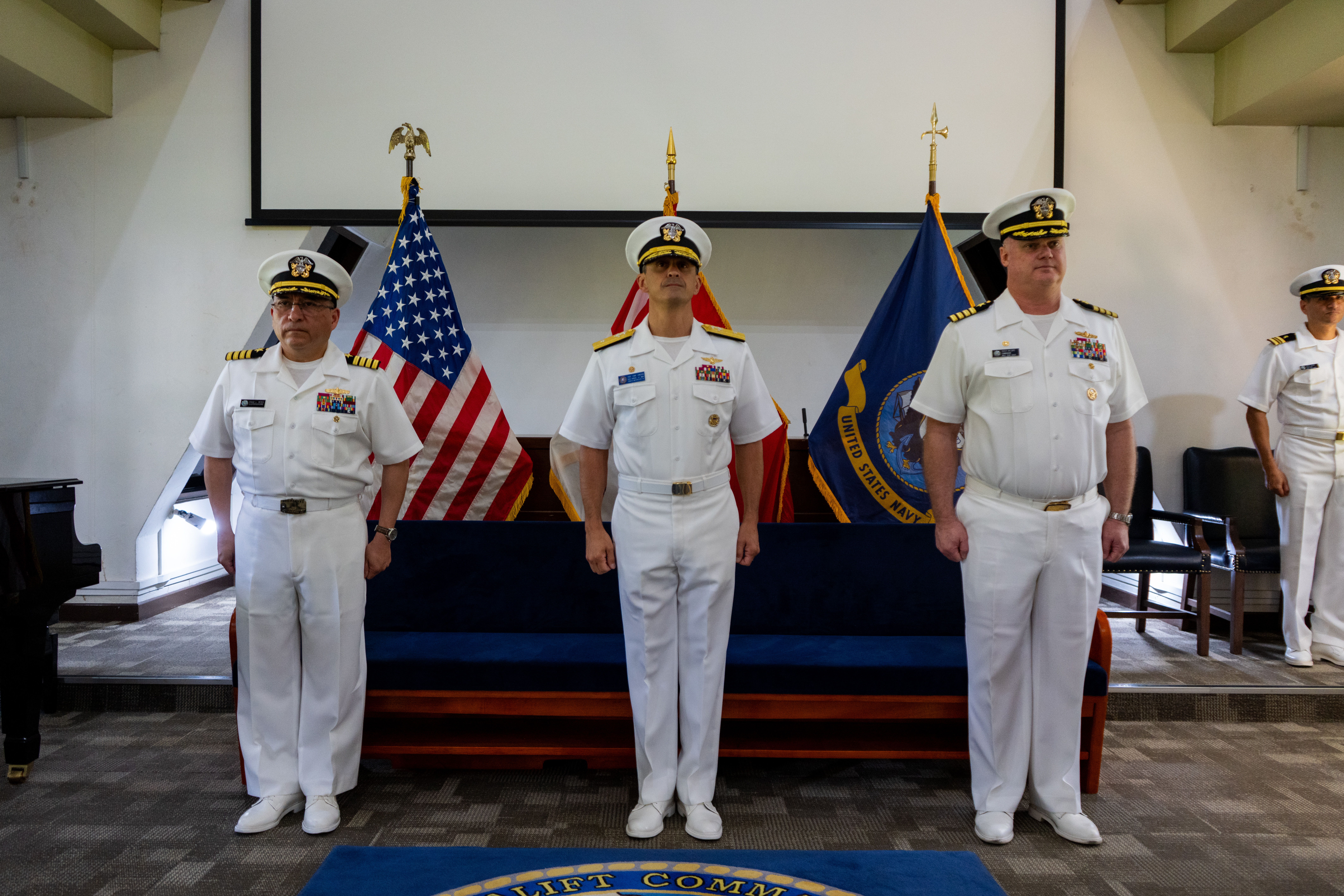 Left to right, Capt. David L. Reyes, incoming commander, Military Sealift Command Far East;  Rear Adm. Todd F. Cimicata, Commander, Logistics Group Western Pacific/ Task Force 73; and Capt. Robert R. Williams, outgoing commander, Military Sealift Command Far East, stand at attention during a change of command ceremony at the Singapore Naval Installation in Sembawang, April 30, 2025.