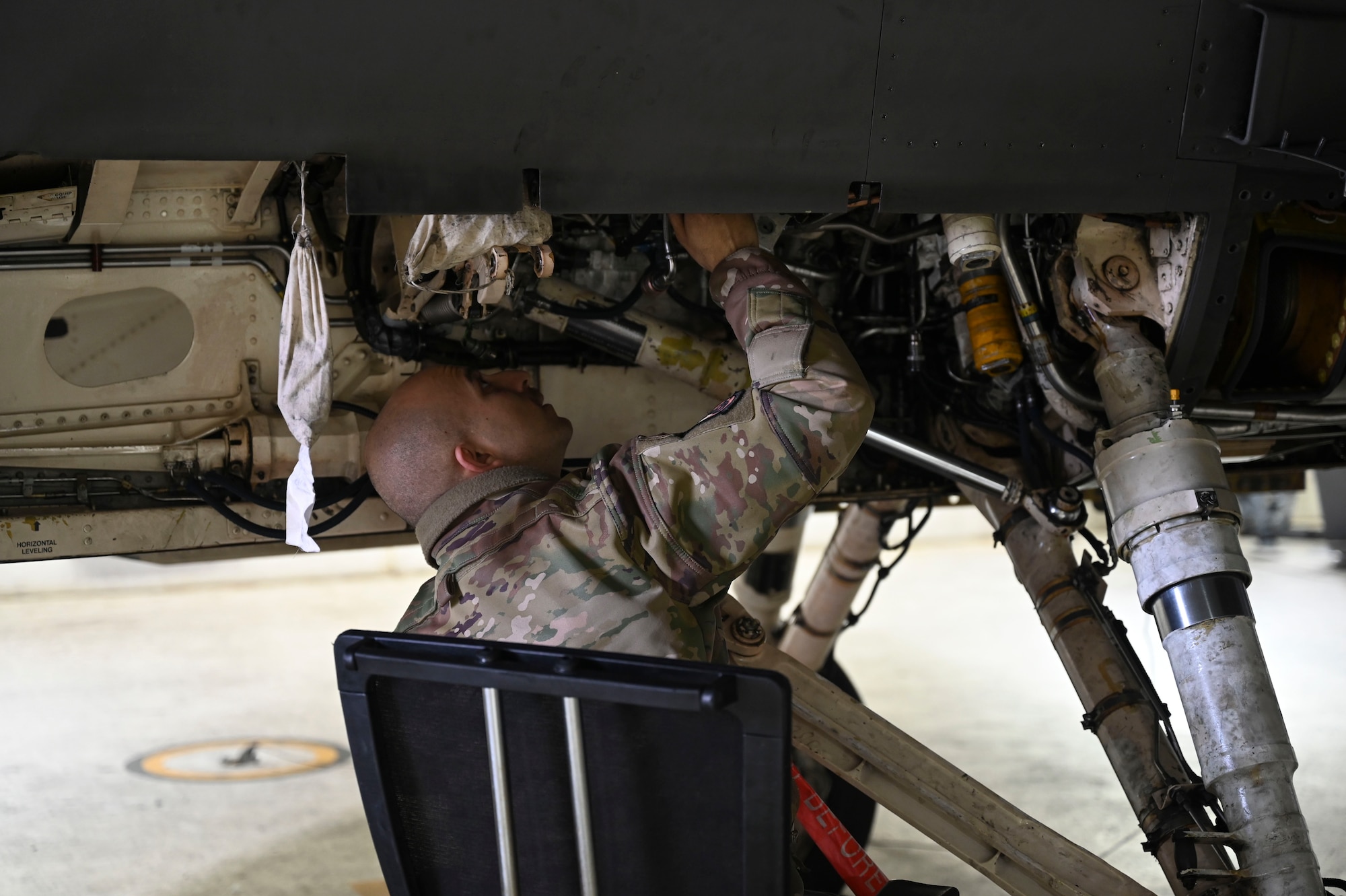 Senior Airman Zachary Collier, 35th Fighter Generation Squadron environmental and electrical specialist, performs maintenance on the underside of an F-16 Fighting Falcon aircraft during Freedom Flag 25-1 at Kunsan Air Base, Republic of Korea, April 23, 2025.