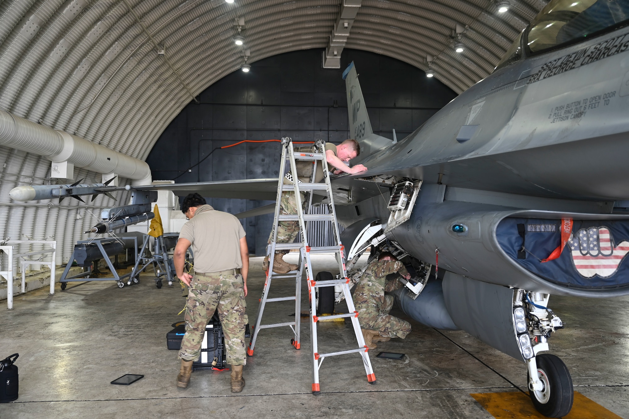 Airman Jose Galindo Barrios, left, 35th Fighter Generation Squadron environmental and electrical specialist, U.S. Air Force Tech. Sgt. Craig Gazette, center, 35th FGS environmental and electrical craftsman, and Senior Airman Zachary Christian, right, 35th FGS fighter integrated avionics specialist, work together to perform maintenance on an F-16 Fighting Falcon aircraft during Freedom Flag 25-1 at Kunsan Air Base, Republic of Korea, April 23, 2025.