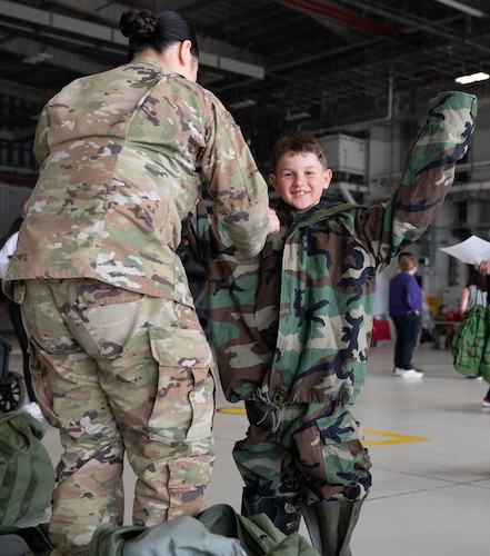 airmen helping put child of airmen in chem gear