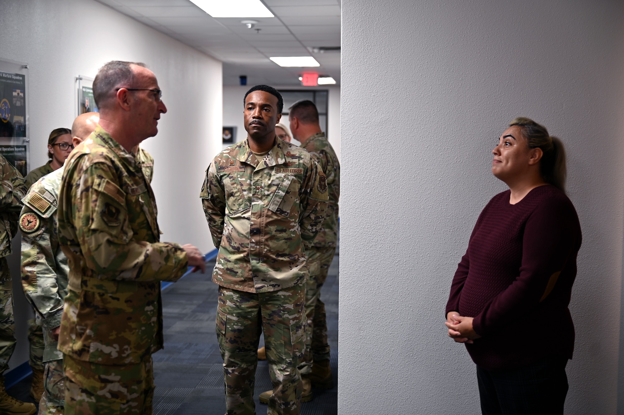 U.S. Air Force Lieutenant General John Healy, Chief of the Air Force Reserve and Commander of Air Force Reserve Command, takes a moment to recognize the achievements of the 960th Cyberspace Wing with Colonel Silas Darden, commander of the 960th Cyberspace Wing (960CW), and Frances Martinez, 960CW director of psychological health at Joint Base San Antonio-Lackland, Texas on April 6, 2025. The 960th Cyberspace Wing's psychological health program has implemented innovative solutions to overcome geographical barriers and provide effective mental health services across its Geographically Separated Units and to Reservists across Joint Base San Antonio. (US Air Force photo by Alex Dieguez)